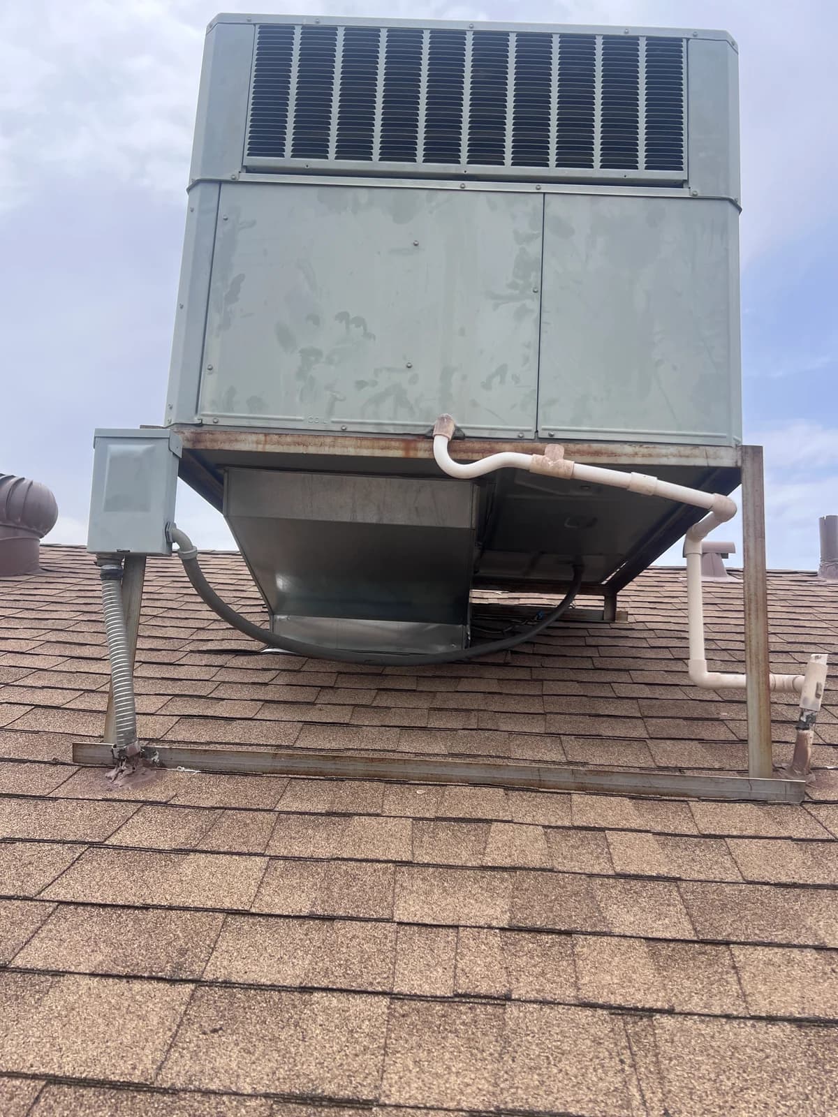 Front view of the original weathered rooftop HVAC unit before replacement