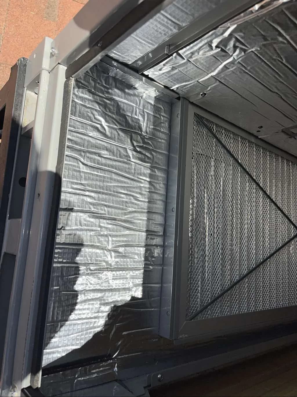 Close view inside the rooftop HVAC system showing carefully sealed surfaces and component access