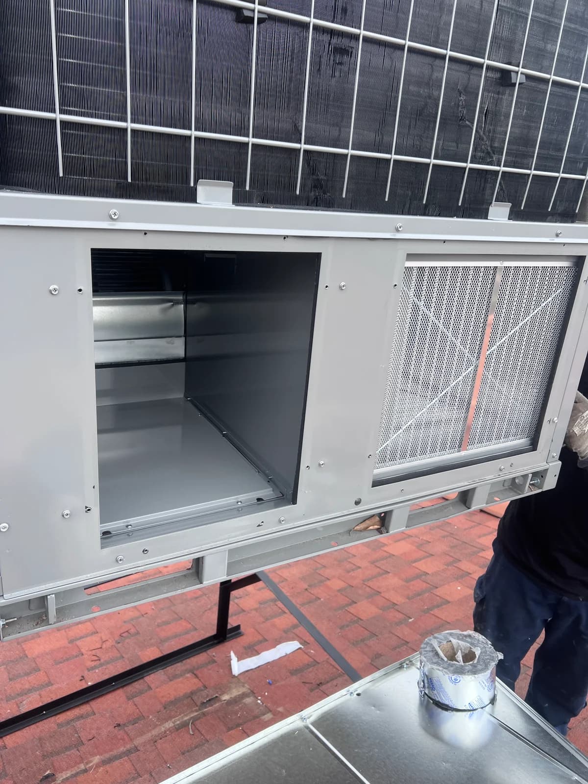 Open rooftop packaged HVAC unit during hands-on service work