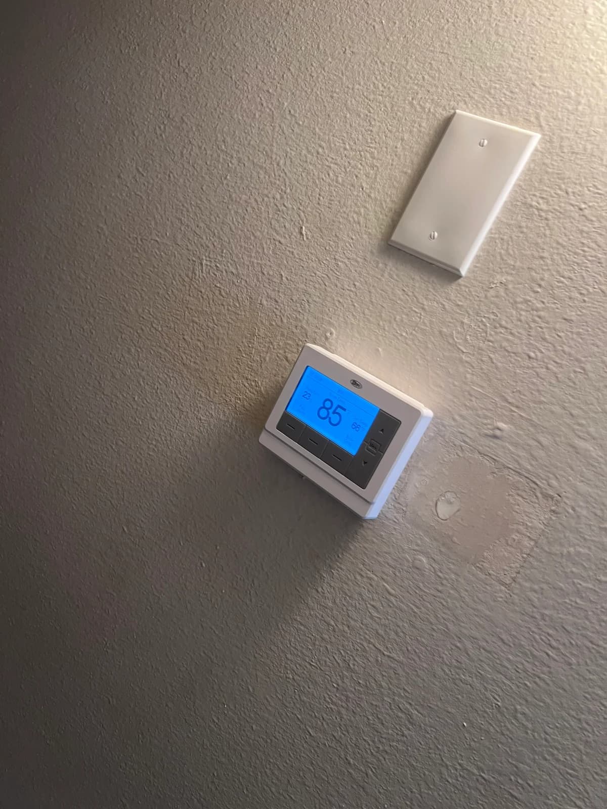 Digital thermostat installed and powered on inside the property