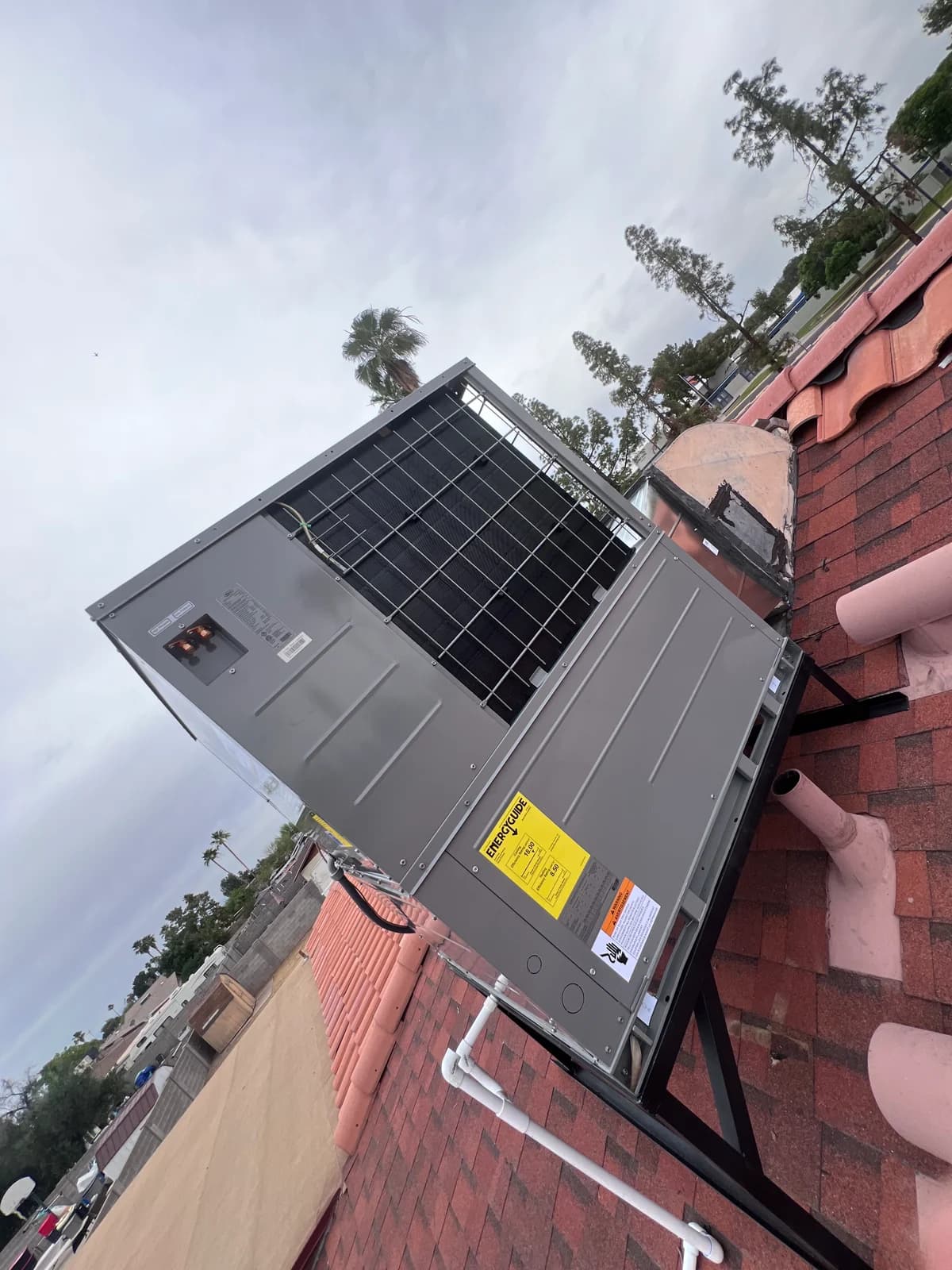 Rear angle of the rooftop HVAC unit showing service labels and roof access